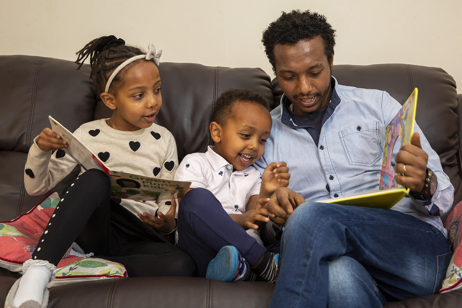 Father with his two young children reading