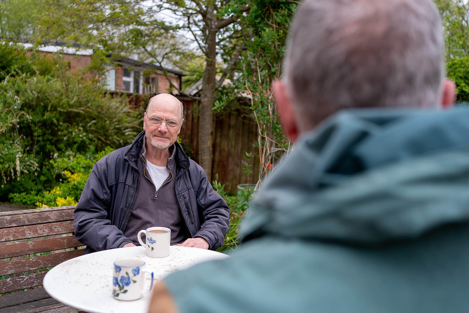 Gentleman meeting having tea in the garden