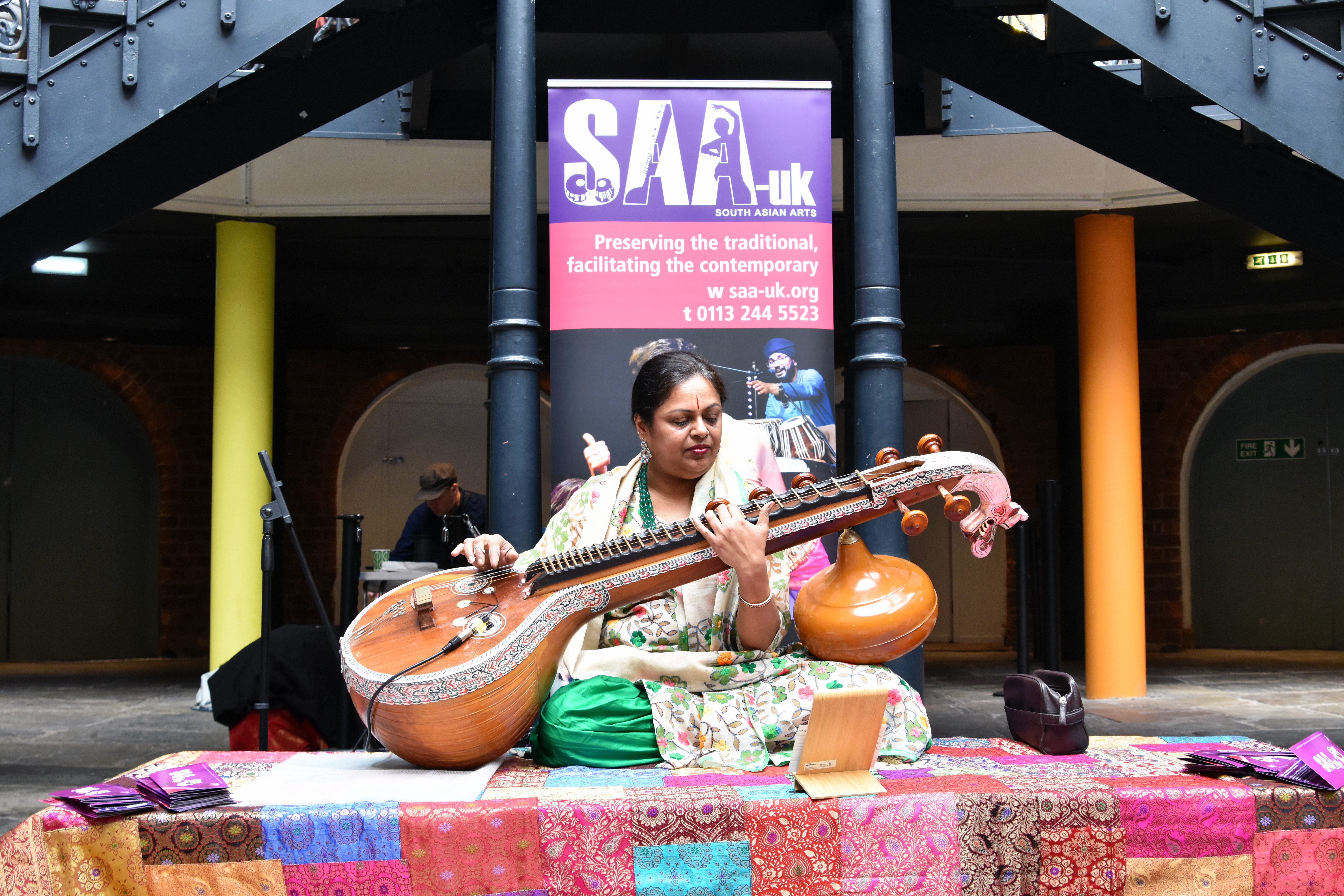 Asian woman playing a sitar on a stage