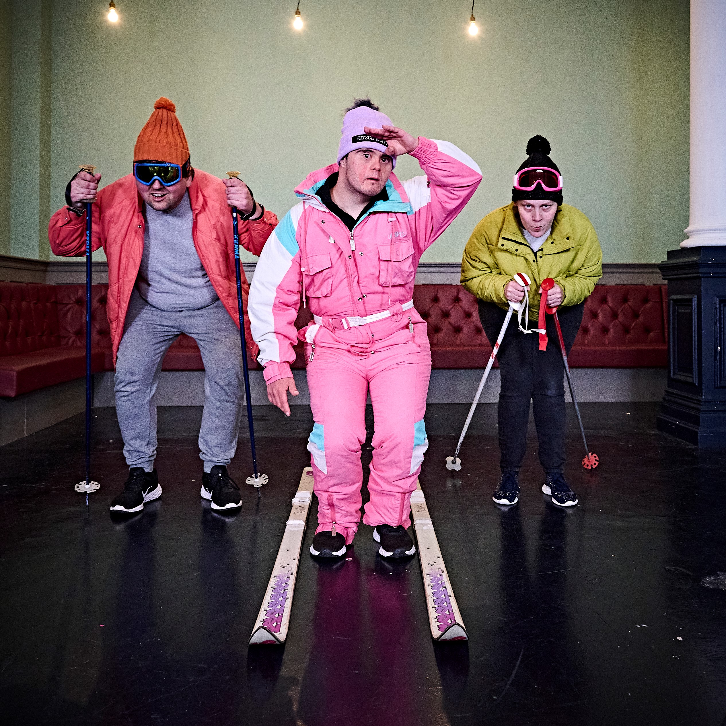 Three people skiing in a room