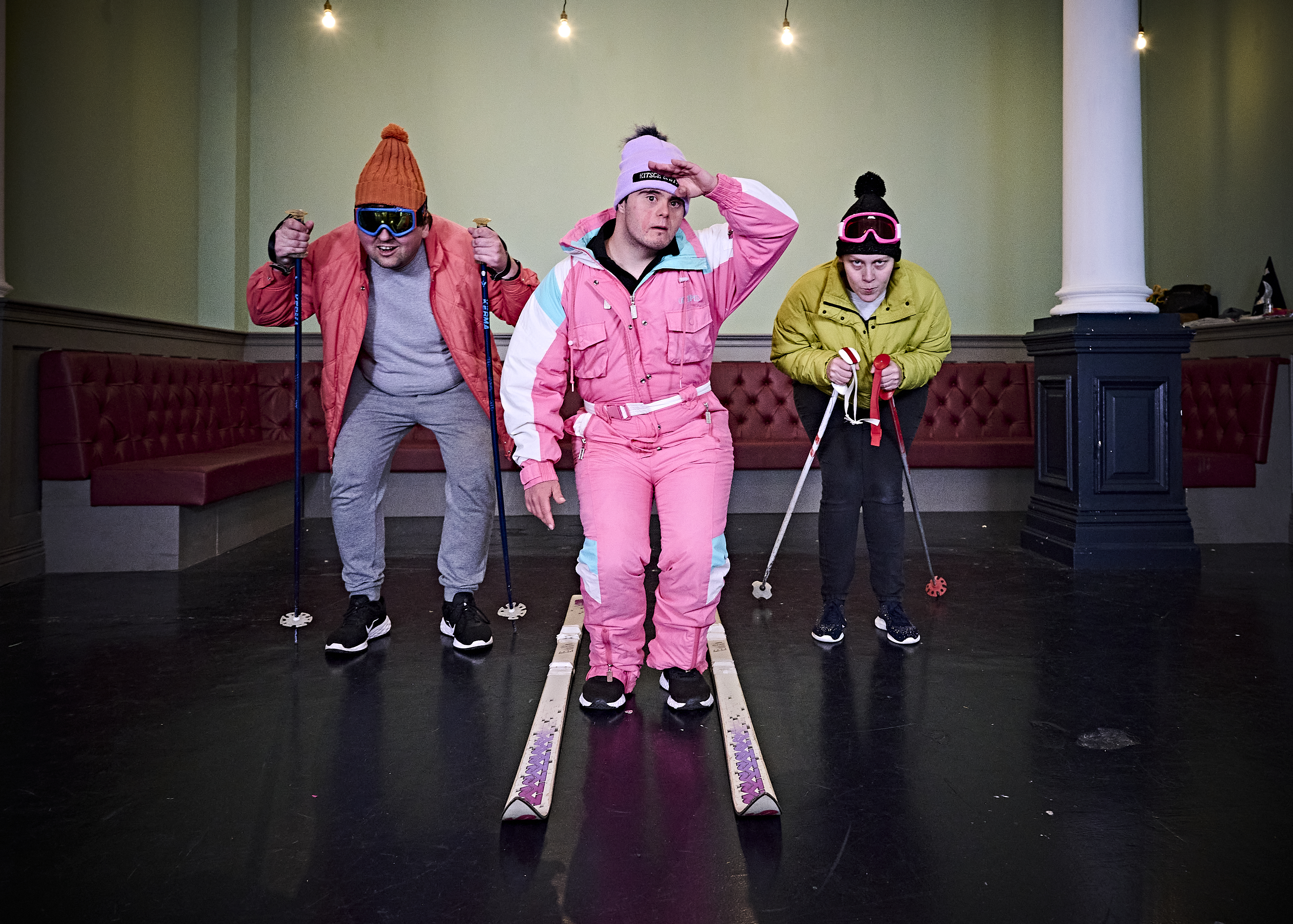 Three people skiing in a room