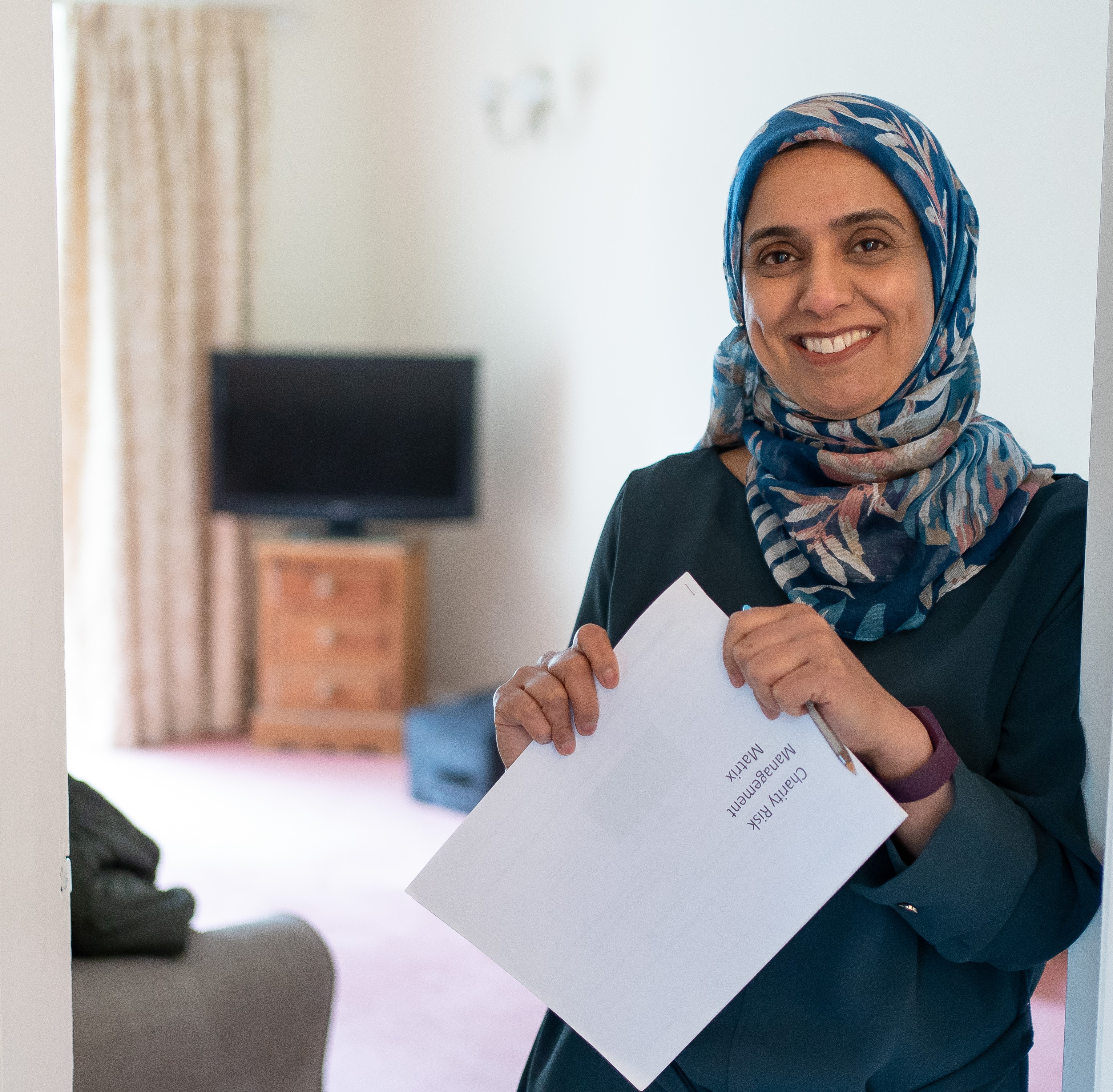 Woman in head scarf looking at the camera smiling