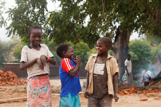 Three African children standing outside