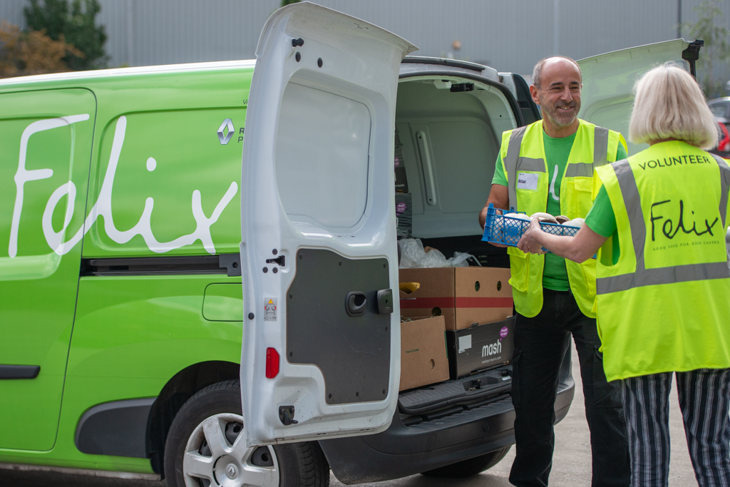 Two people loading a van with food