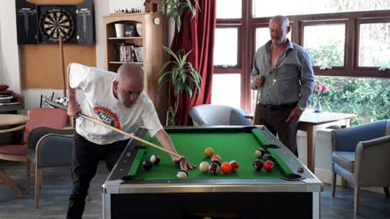 Two older men playing snooker