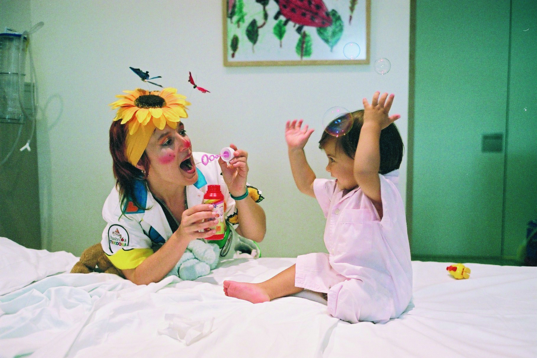 A giggle doctor blowing bubbles at a child