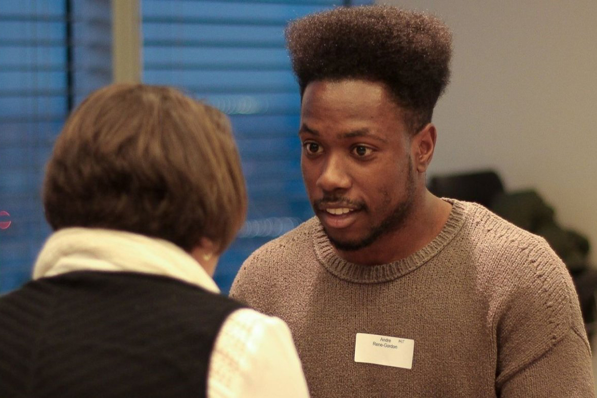 A black man talking to someone with their black to the camera