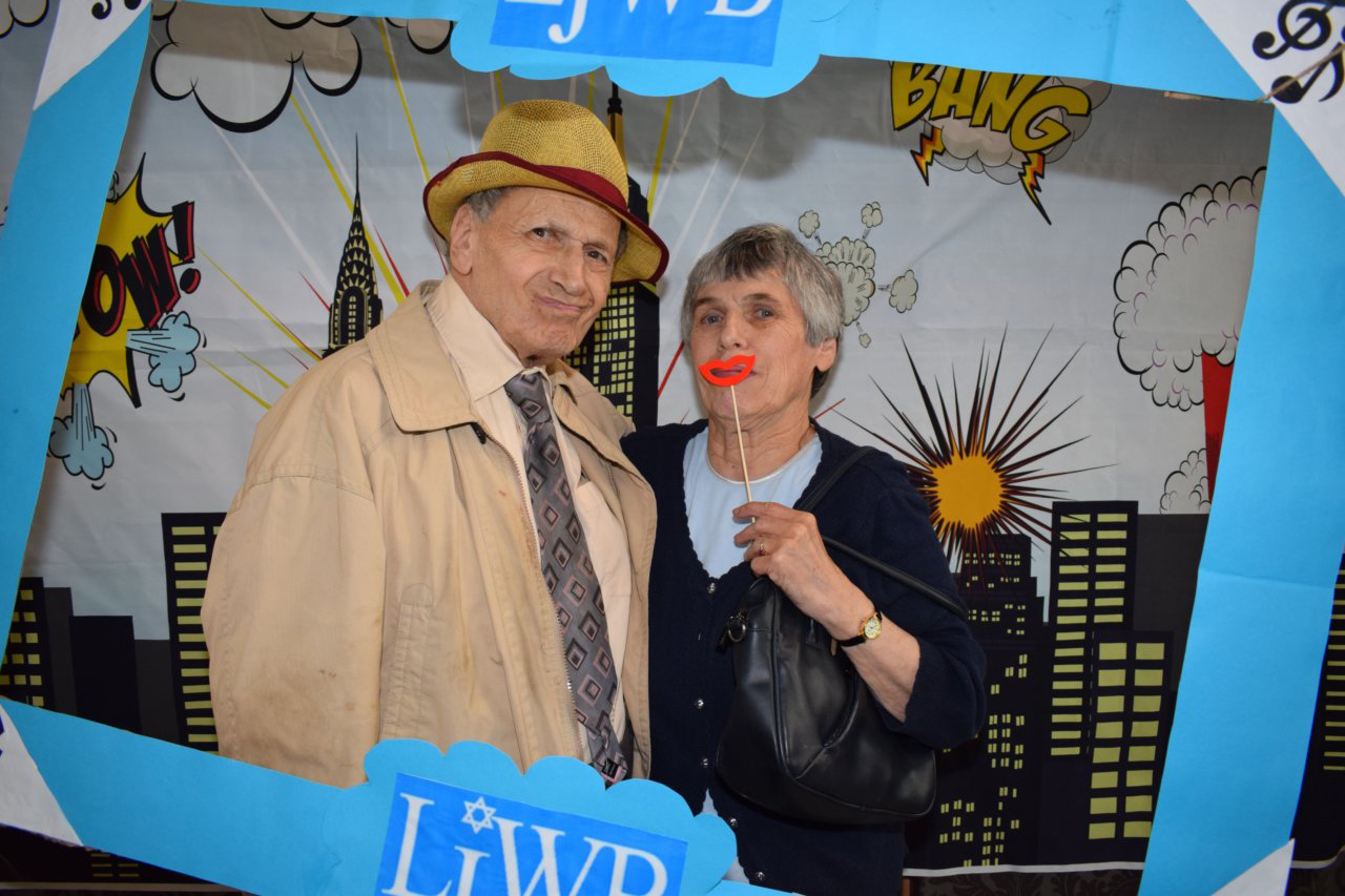 Two older people posing in a photo frame