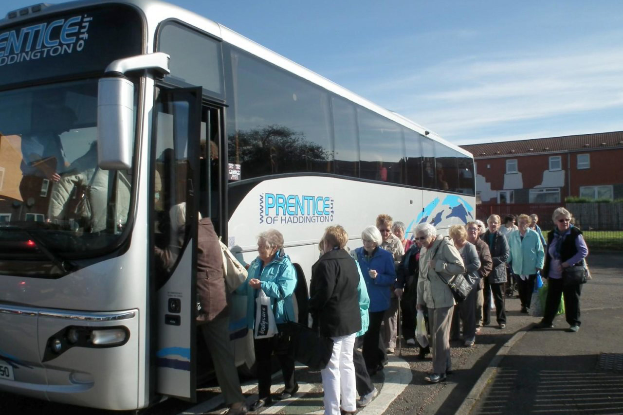 A group of older women getting on a coach