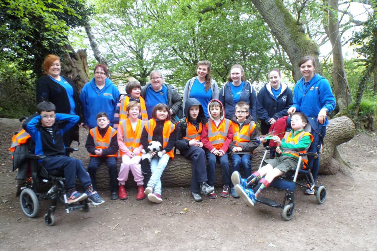 A group of disabled children in a forest posing for the camera