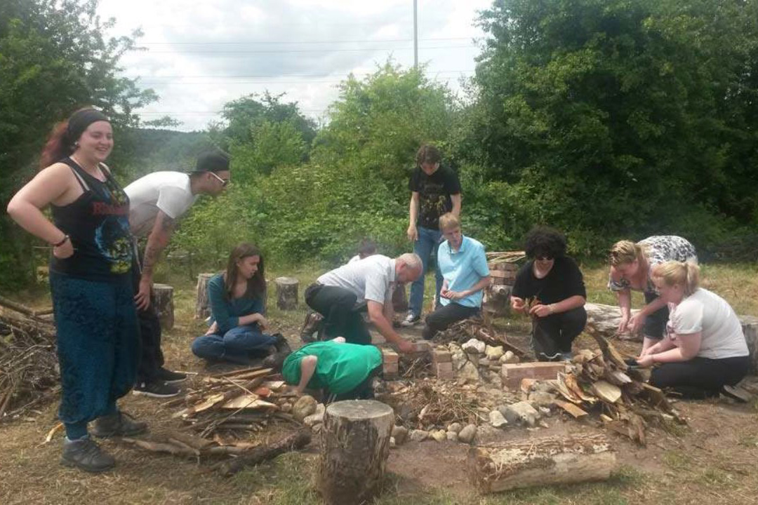 A group of people outdoors chopping wood