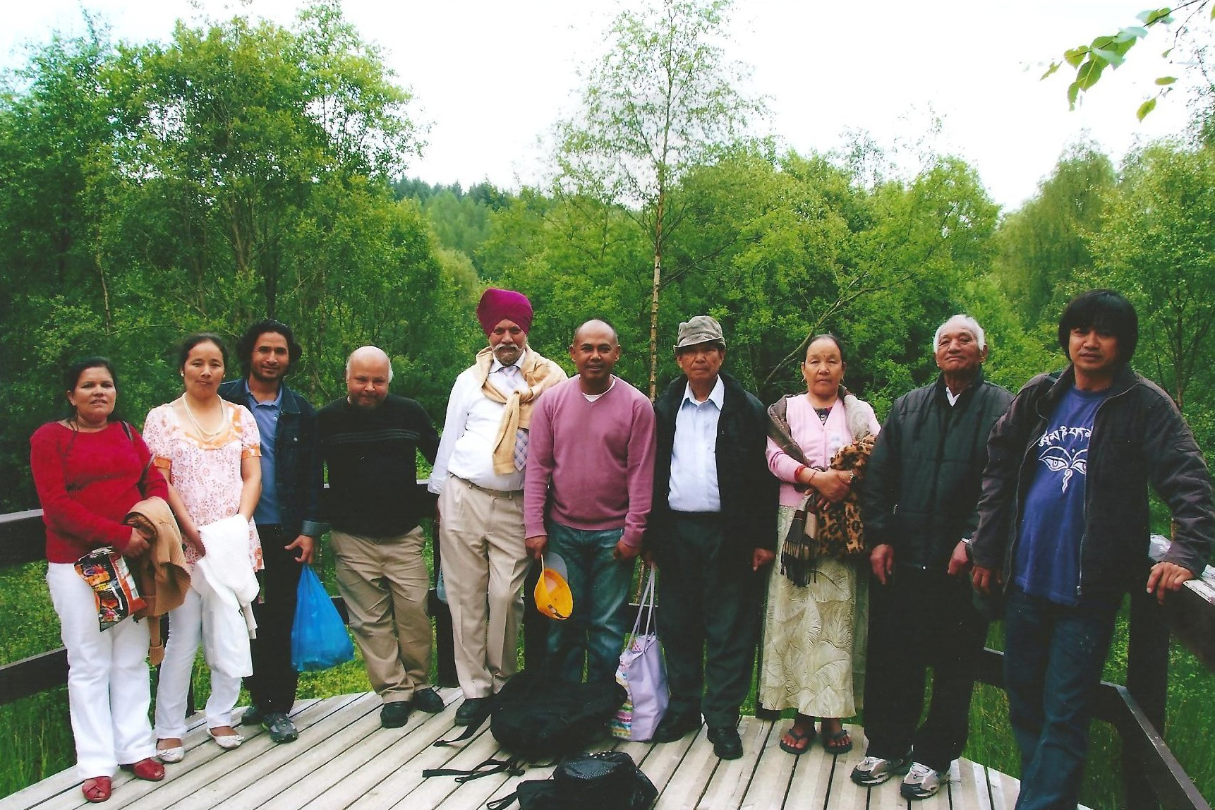 A group of Asian people posing for a camera in a park