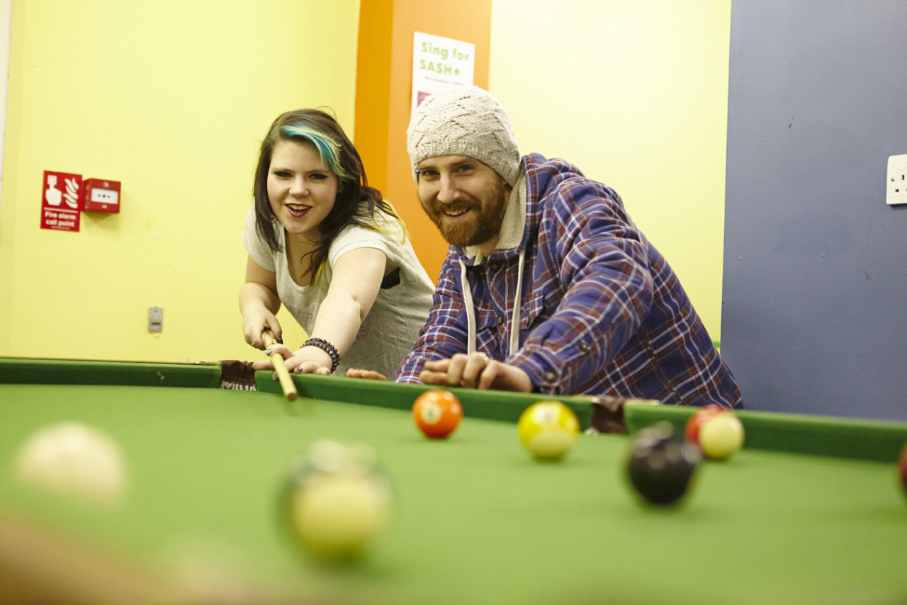 Two people playing pool