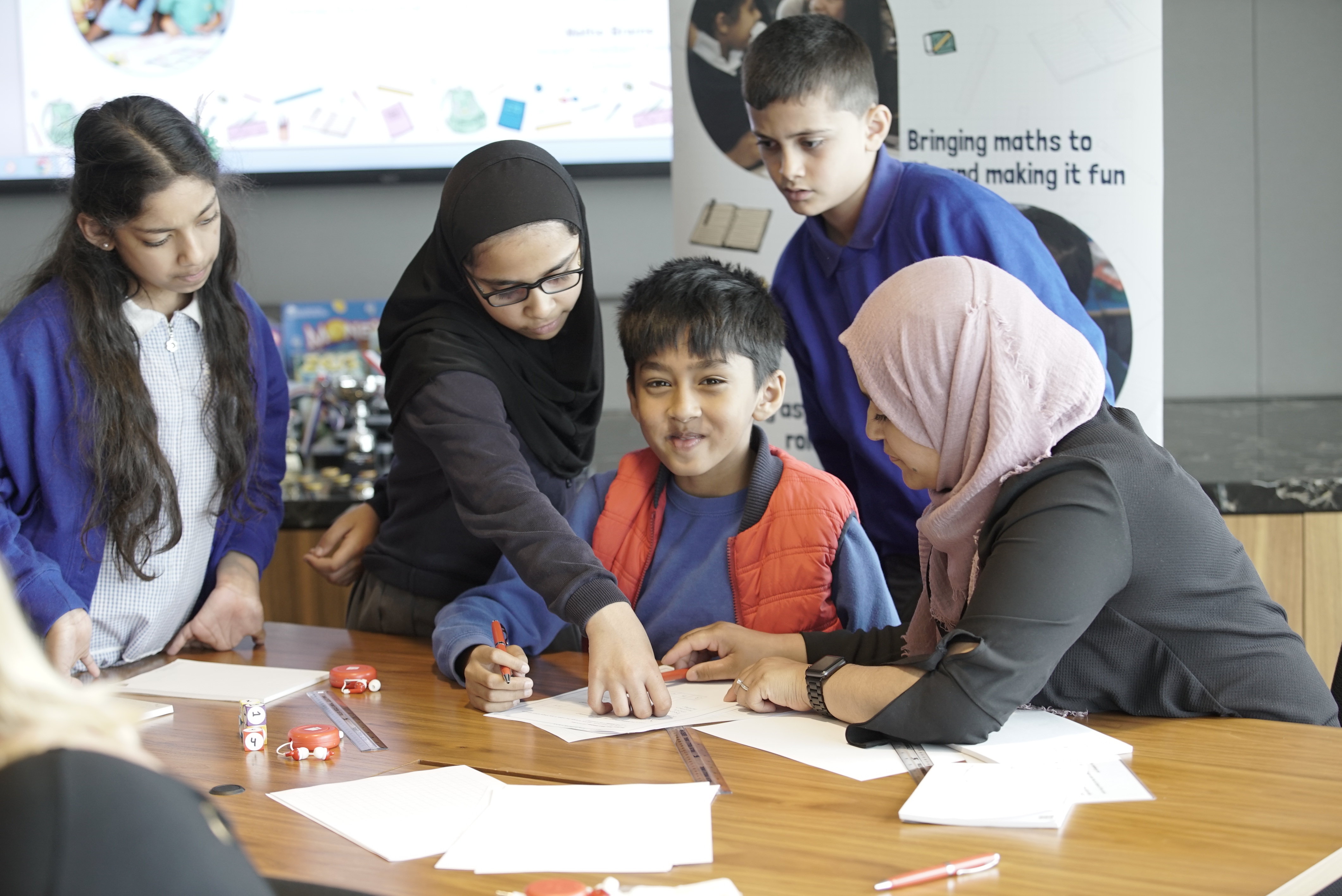 Asian children helping a boy with his homework