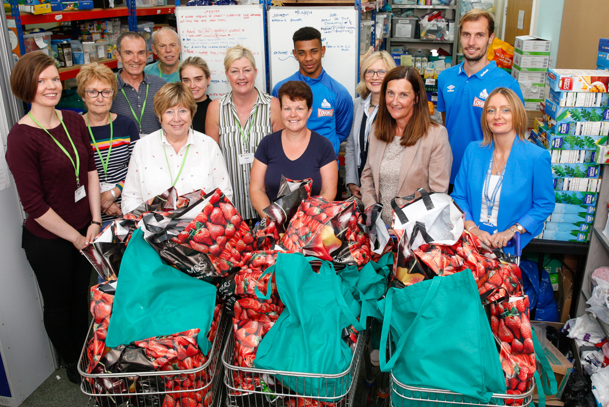 A group of people with full shopping trollies