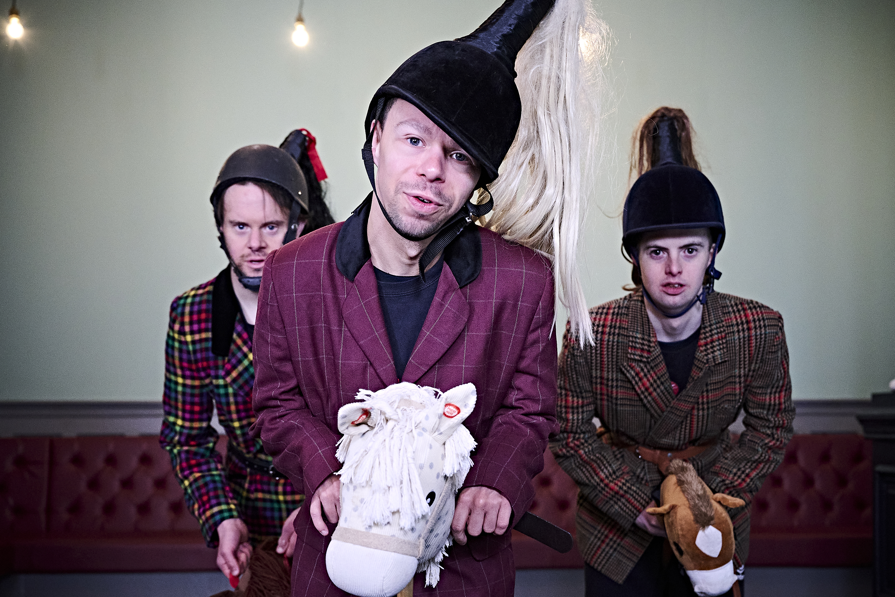 Three people riding hobby horses