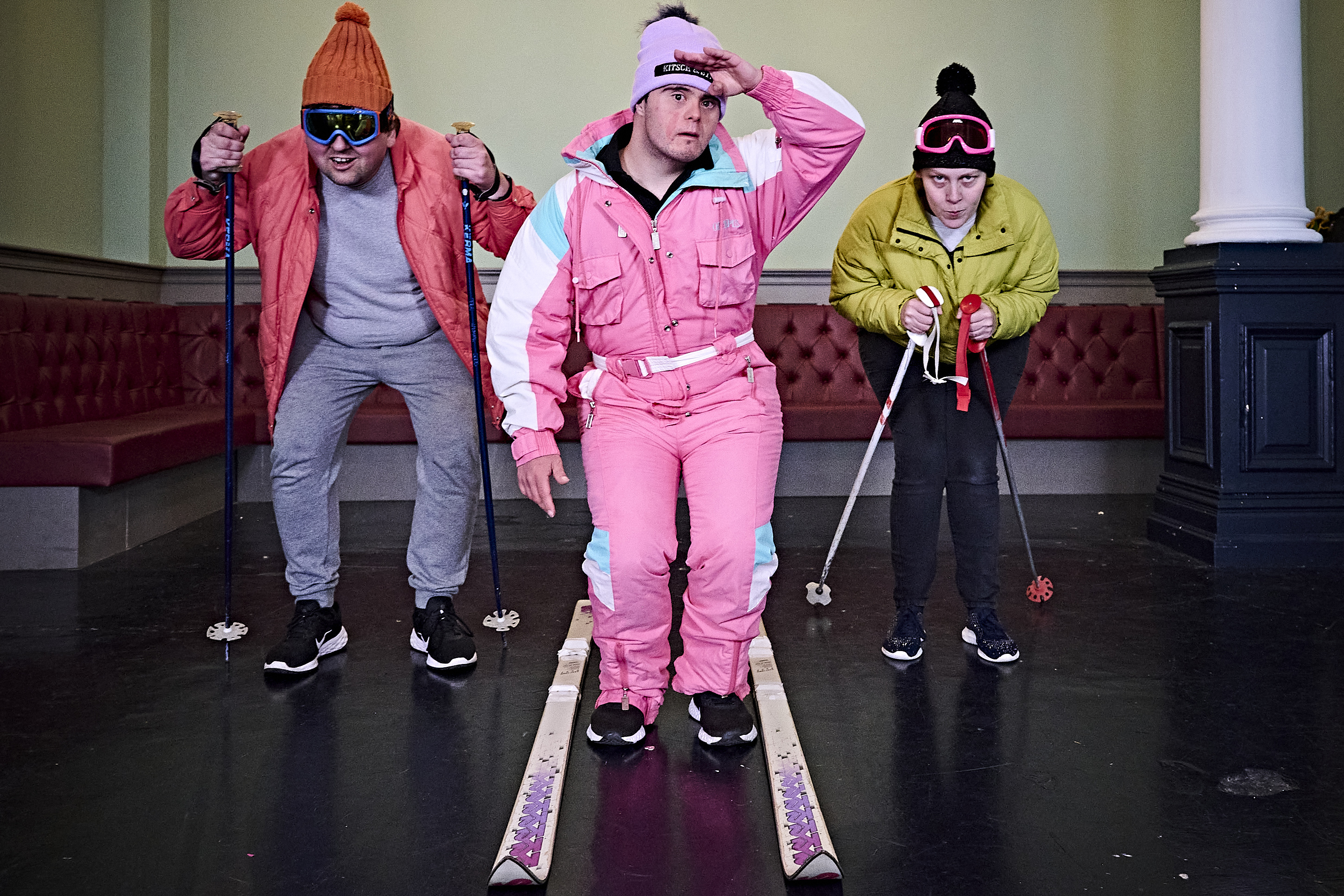 Three people in skiing costumes rehearsing a play