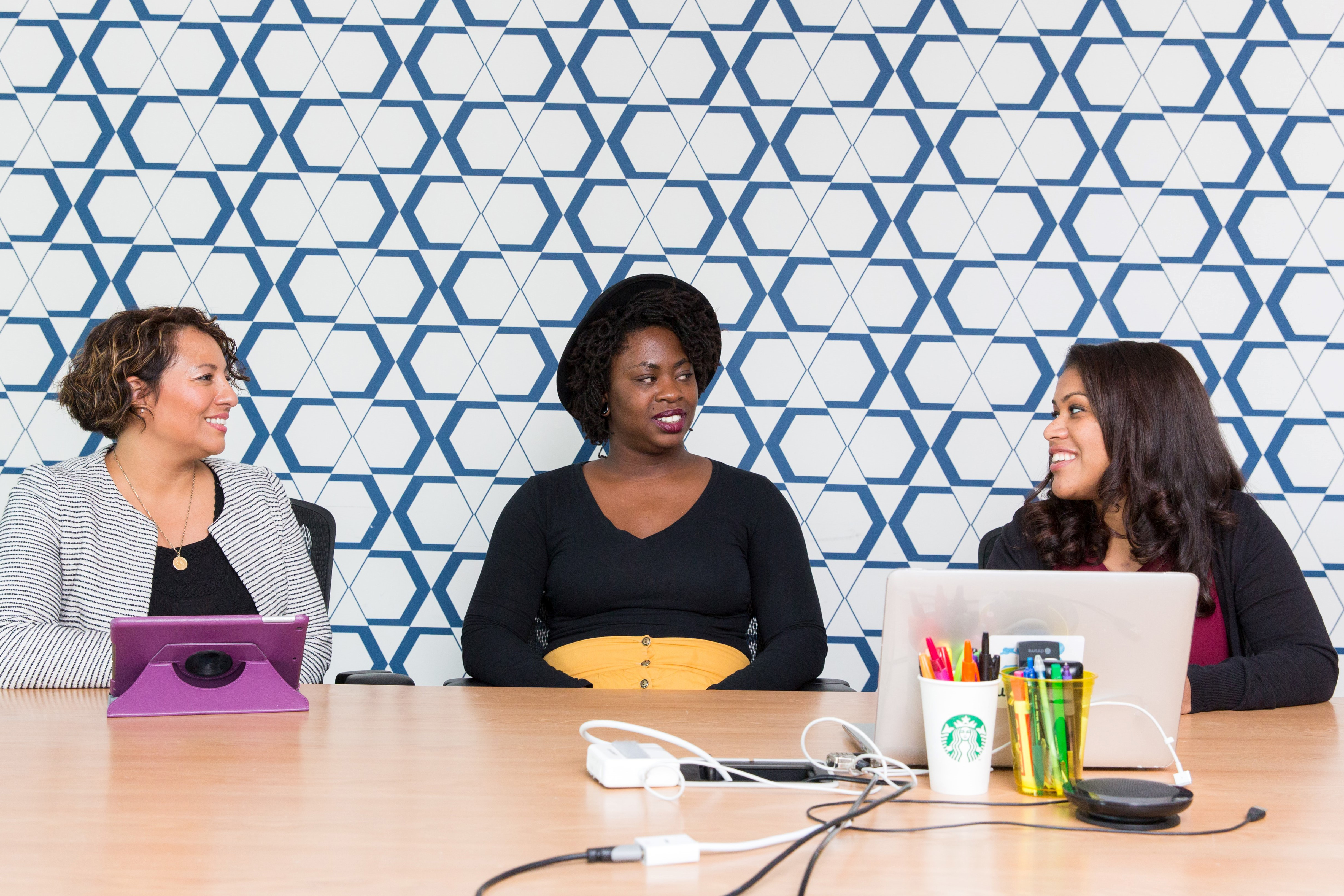 Three people sitting at a table talking to each other