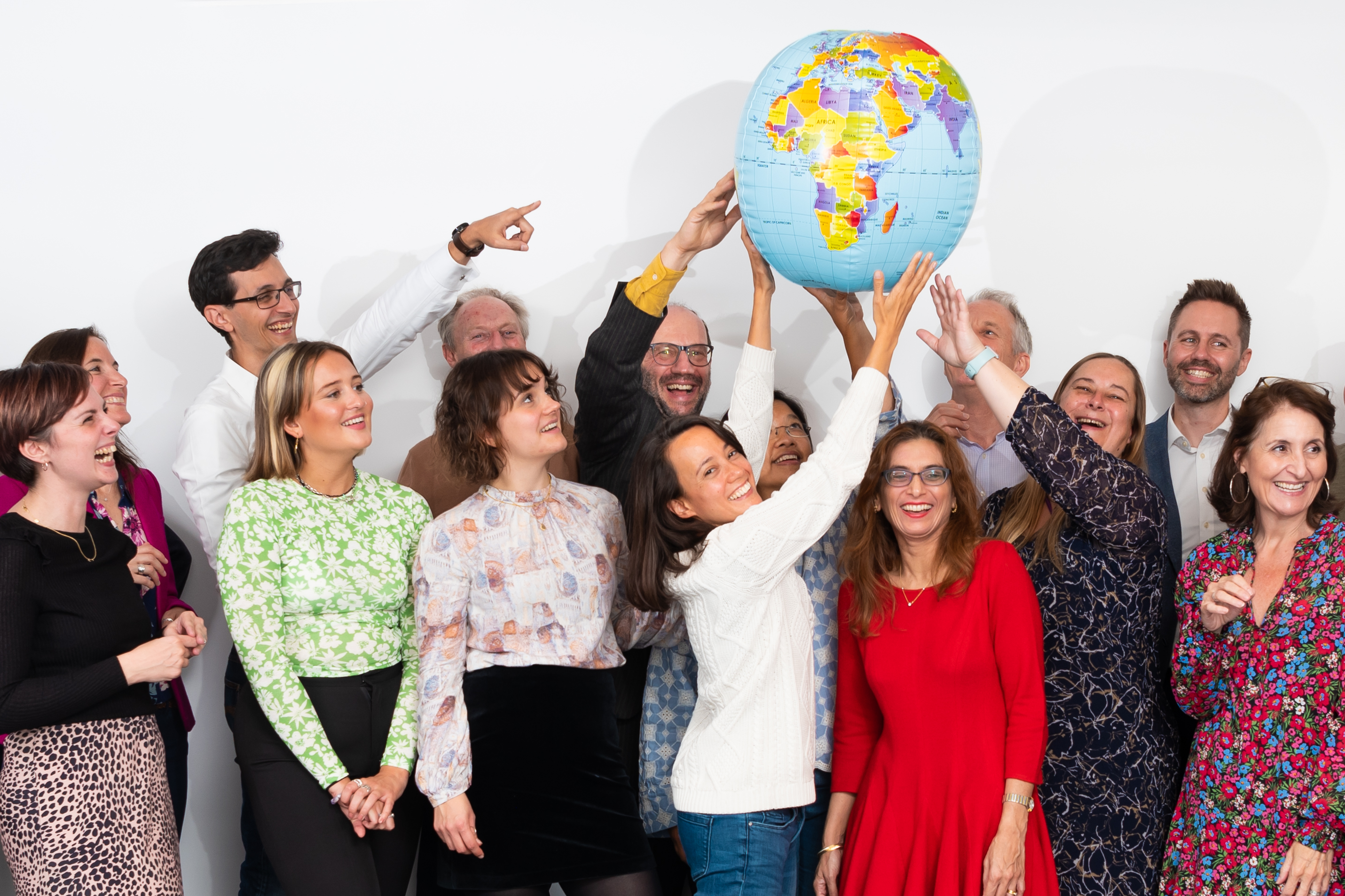 A collection of Pilotlight staff holding an inflatable world