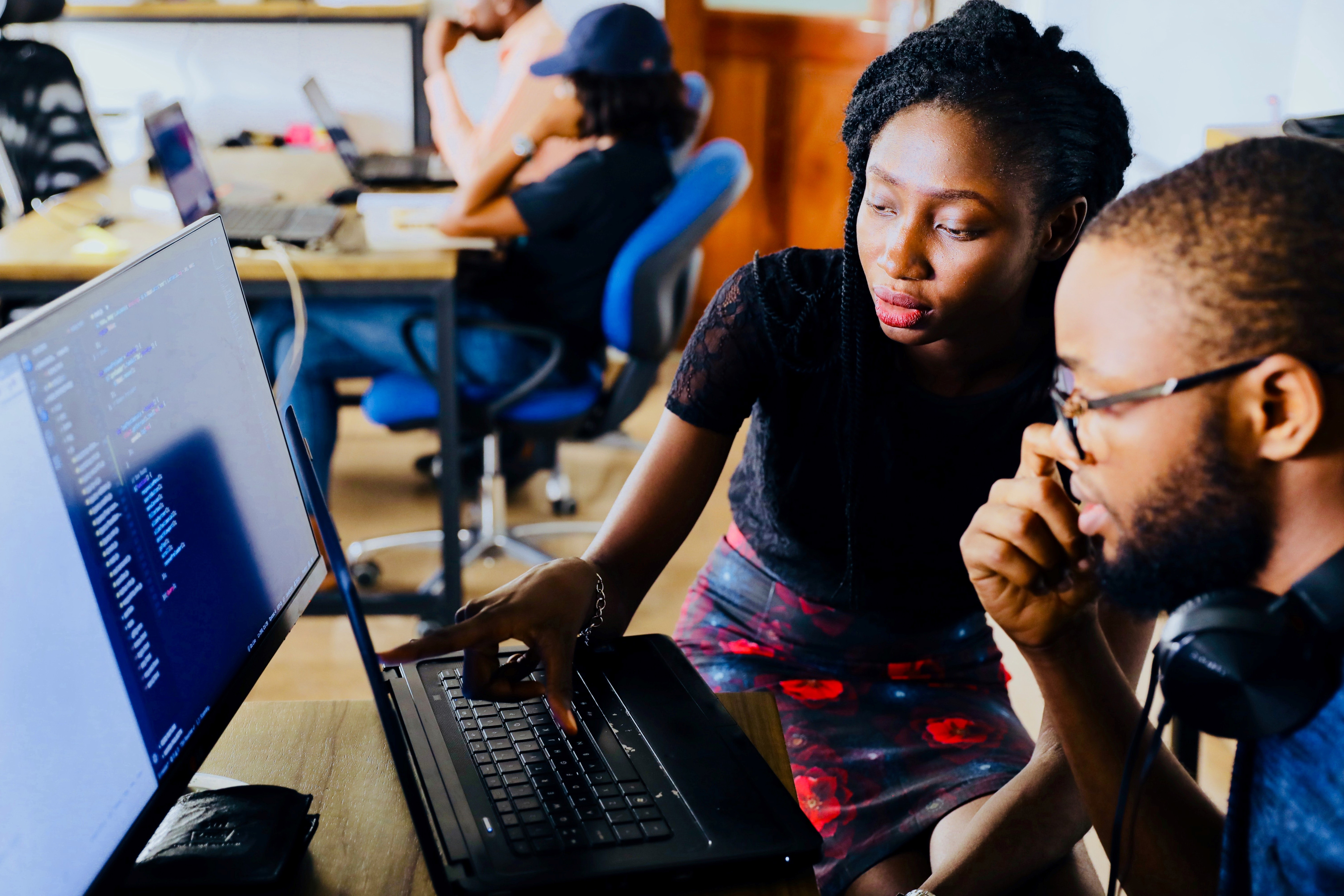 Two black people looking at a computer screen