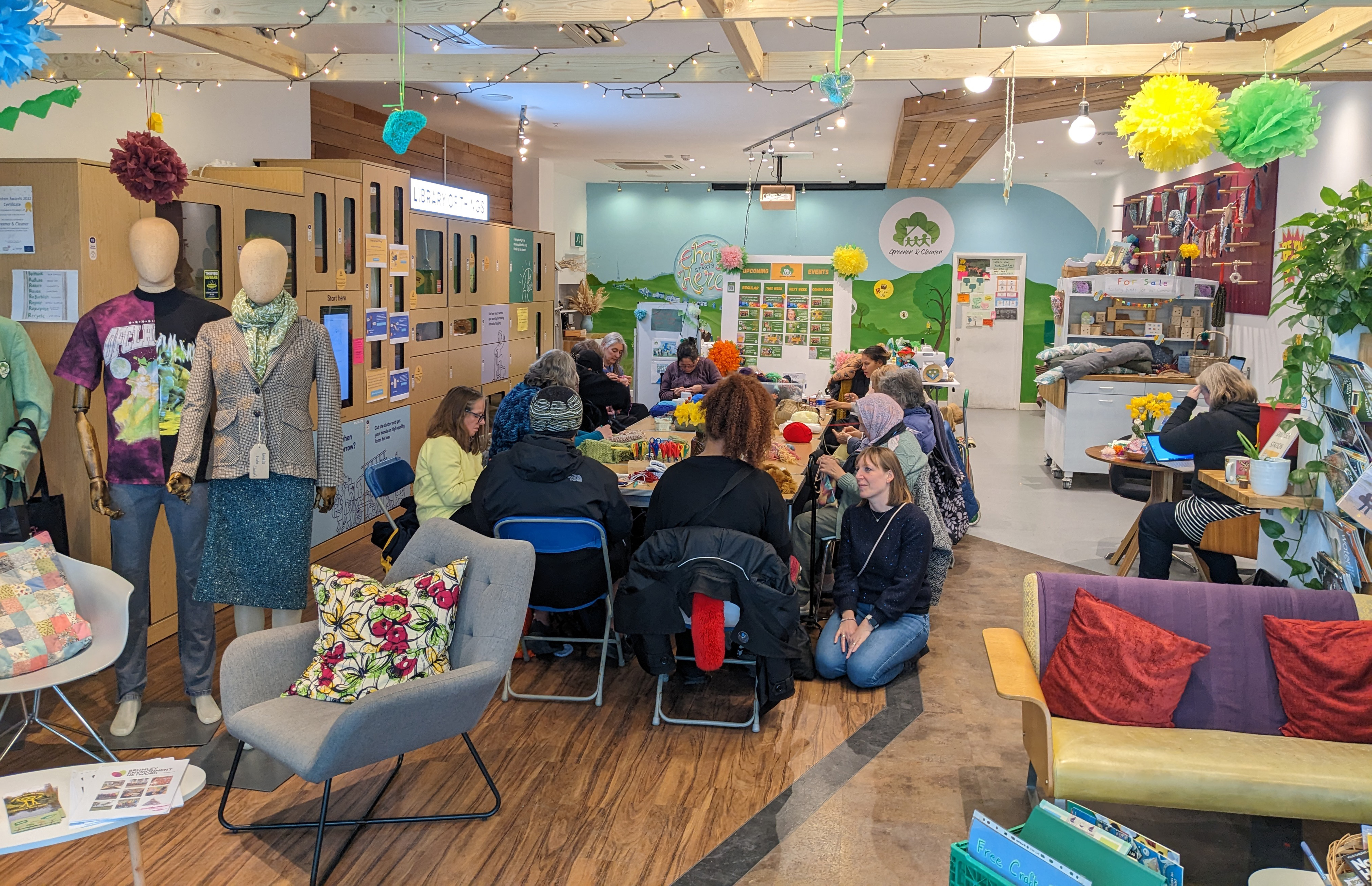 Inside of Greener and Cleaner's 'Hub' where a group of people are sitting around a table doing an activity