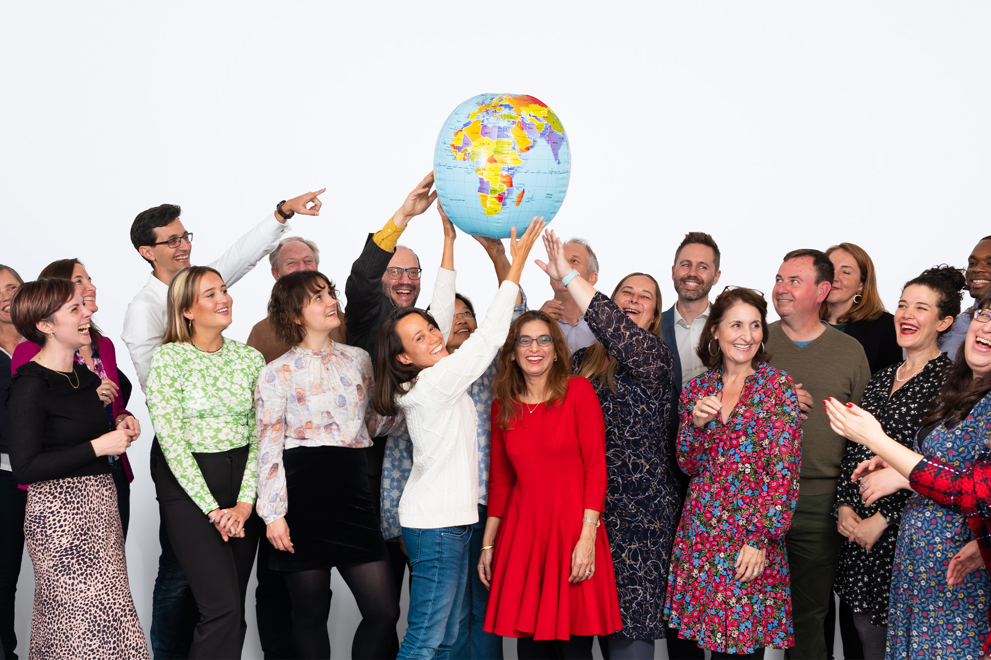 Pilotlight team all holding an inflatable world ball