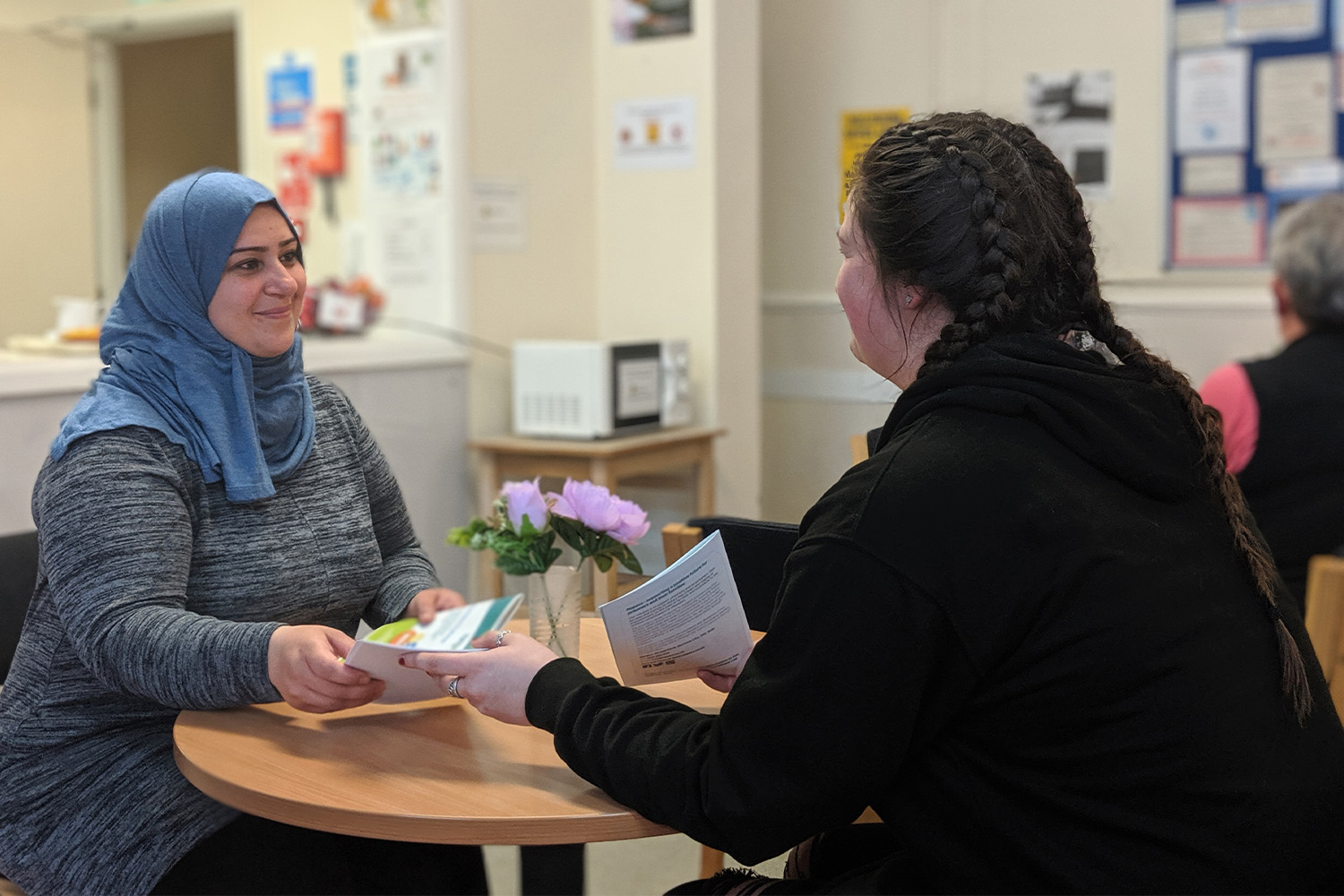 people exchanging pamphlets &amp; smiles