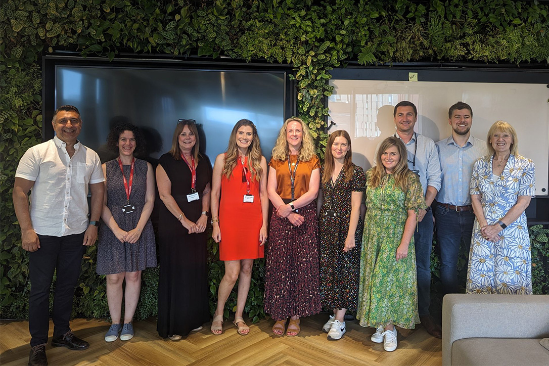 Pilotlighters with the team members of A Child of Mine in front of a living wall