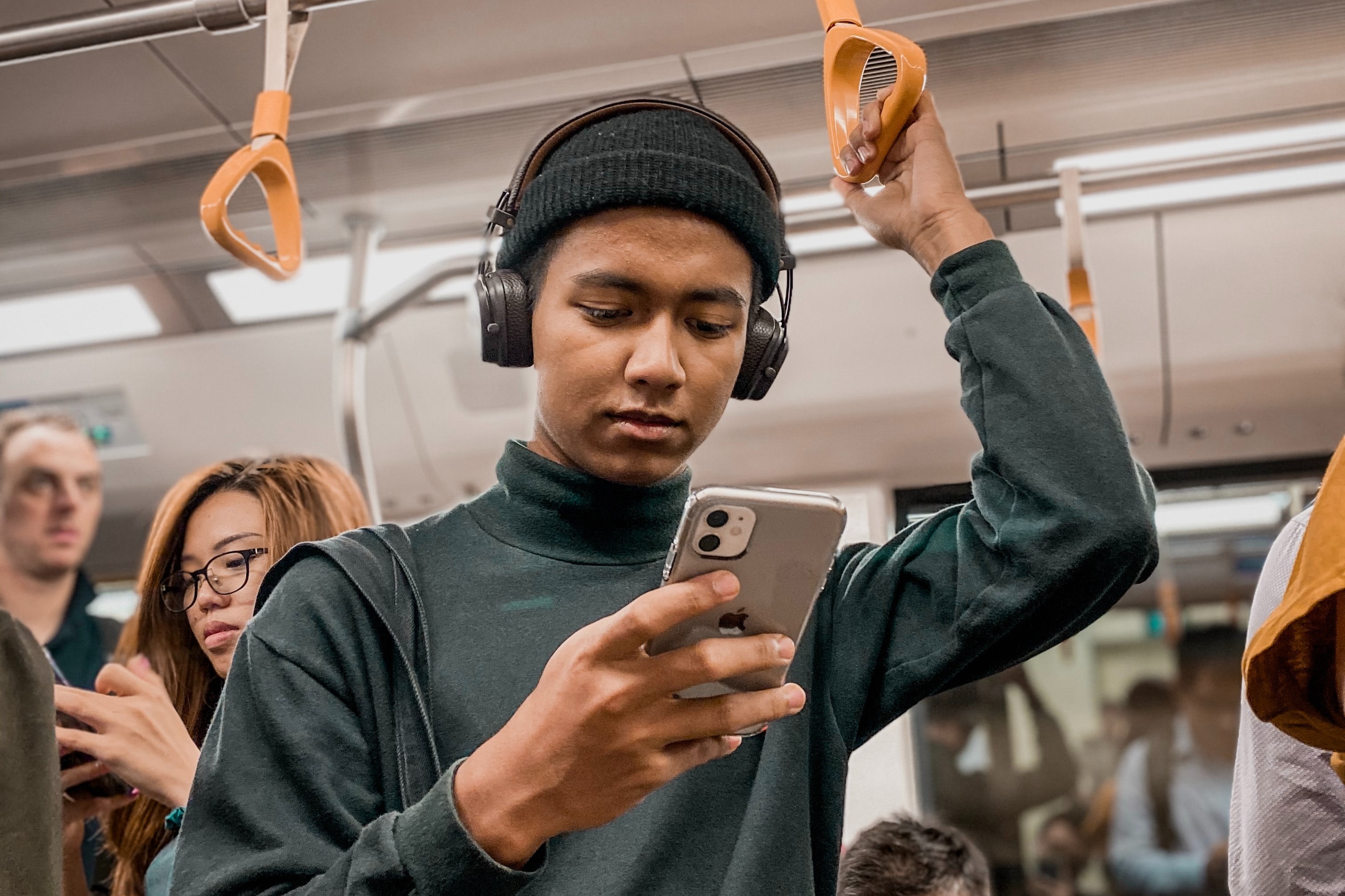 Man on an underground train looking at his phone