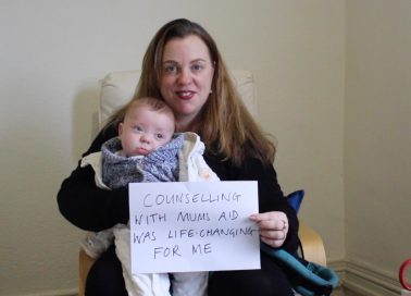 Mum holding a baby and a sign that reads counselling with MumsAid was life changing for me