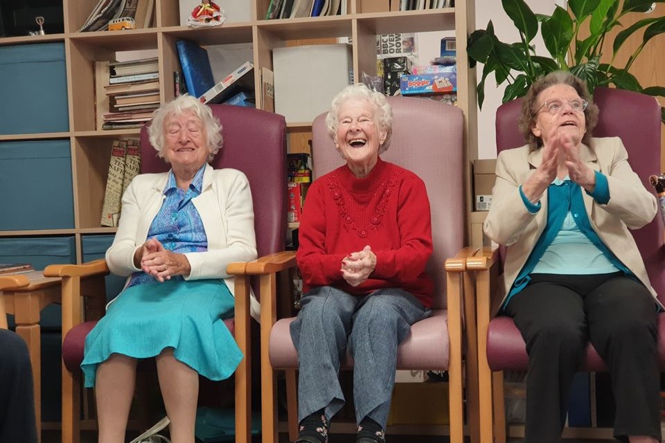 Three ladies sitting in a row