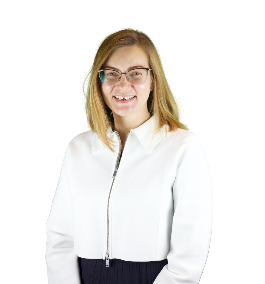 Trustee Iana wears a white zip up jacket and smiles at the camera.